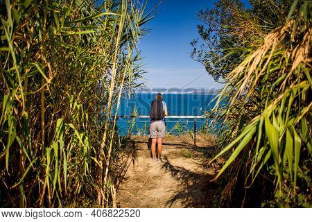 A Woman Hiker With A Backpacker In A Reeds Path Looking The Sea Of Strunjan, Slovenia