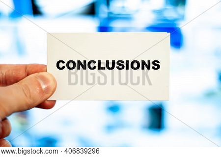 Businessman With A White Business Card With The Words - Conclusions On A Blue Screen Background.