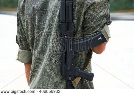 A Young Man In Camouflage Uniform With A Soviet-russian Machine Gun On His Back. Outside The Premise