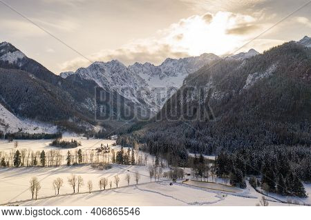 Aerial Winter Landscape With Mountain Village And Forest Covered In Snow. Zgornje Jezersko, Slovenia
