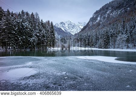 Frozen Winter Lake In The Mountains Covered With Snow. Plansar Lake, Jezersko Slovenia.