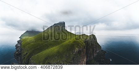 Aerial Panorama Of A Small White Lighthouse Located On The Edge Of A Huge Cliff And The Island Of Ka