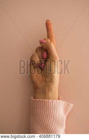 A Female Hand With The Index Finger Pointing Up Gesture
