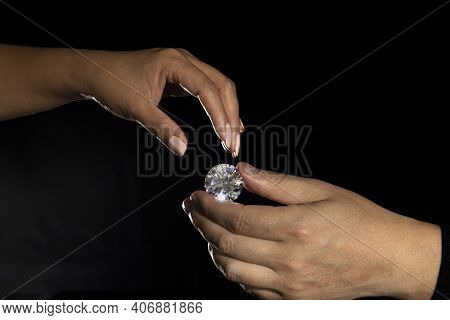 Large Polished Round Cut Diamond In Hand Close Up Front View. High Quality Photo