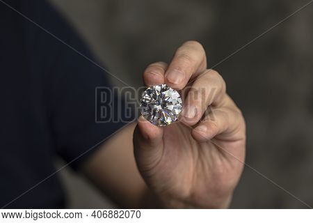 Large Polished Round Cut Diamond In Hand Close Up Front View. High Quality Photo