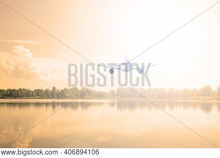 Airliner Over The Lake And Forest. Evening Sunset