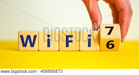 Wifi 6 Or 7 Symbol. Businessman Turns A Wooden Cube And Changes The Words Wifi 6 To Wifi 7. Beautifu