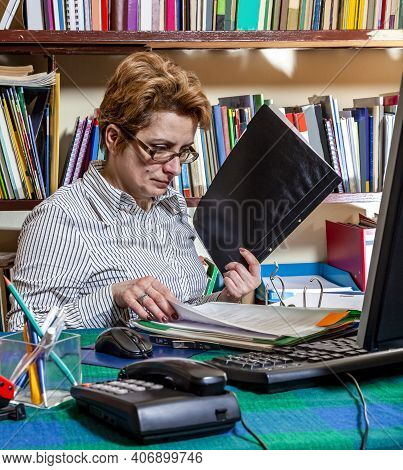 Image Of A Busy Woman Telecommuting At Her Desk At The Home. Working At Home Became An Important Rec