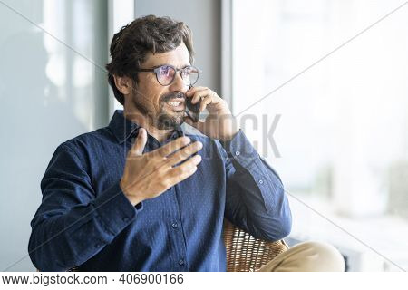 Casual Businessman Wearing Glasses Talking On The Phone. Successful Male Portrait Sitting On A Shair