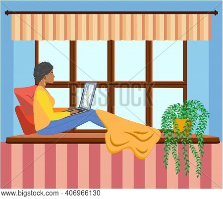 A Woman Works At A Laptop While Sitting On The Windowsill At Home. Freelance Concept, Quarantine Due