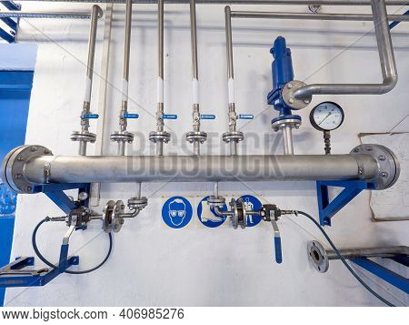 Chrome Steel Gas Pipes With Ball Valves And Fittings On The Wall. The Main Bio Methane Pipeline With