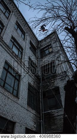 Brave Man Jumping From Roof To Roof. Courage And Adrenaline Concept. Guy Doing Scary Jump Between Ro