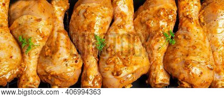 Raw Chicken Drumsticks Marinated Red With Turmeric, Garlic, Mustard And Parsley. Lined With Chicken
