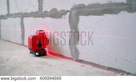 Male Tiler Put Ceramic Tiles On Wall In Bathroom, Laser Level Highlights Place Of Installation, Prof