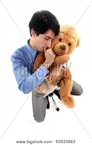 Businessman hugging teddy bear