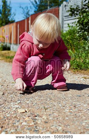Little Girl Plays With Pebbles