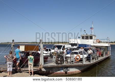 loading of trucks on a small ferry across the Volga.