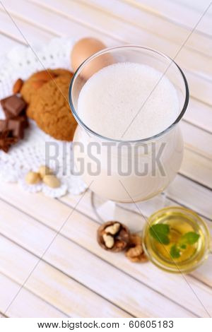 Eggnog with cookies on wooden table