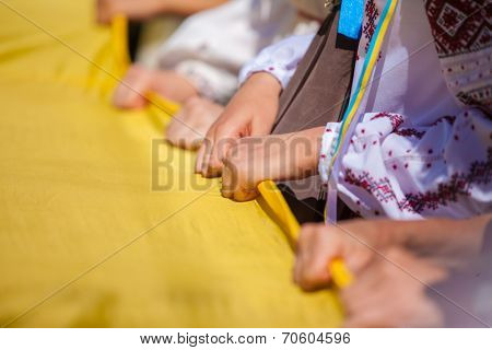 ODESSA, UKRAINE - August 23: Flash mob in city of Odessa on Potemkin Stairs on August 23, 2014, in day of a national flag of Ukraine. Hands of participants of Flash mob in Odessa with a flag