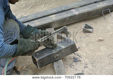 Workers at construction site cutting metal using blowtorch
