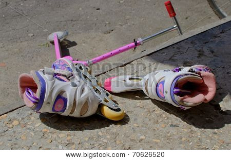 A Pair Of Children's Roller Skates And Scooter