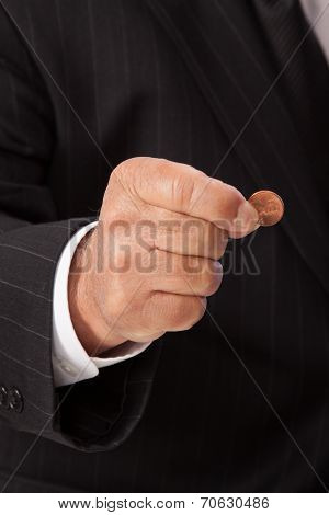 Man's hand pinching penny-vertical