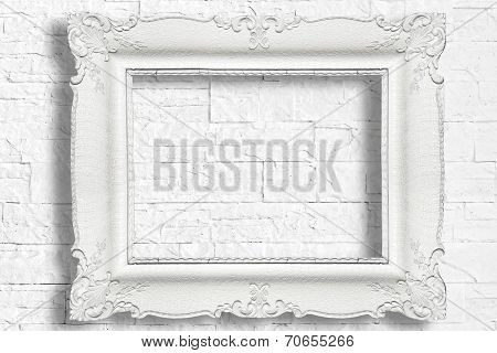 White baroque frame on modern brick wall
