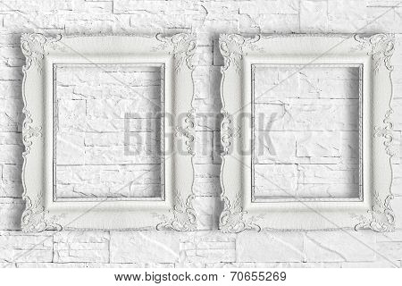 Two white frame on brick wall