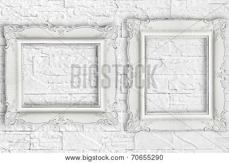 Two white frame on brick wall