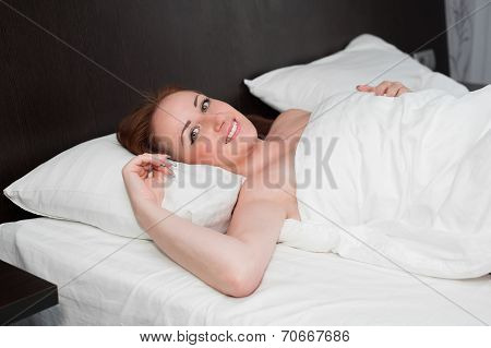 Smiling Young Woman Wakes Up On Bed