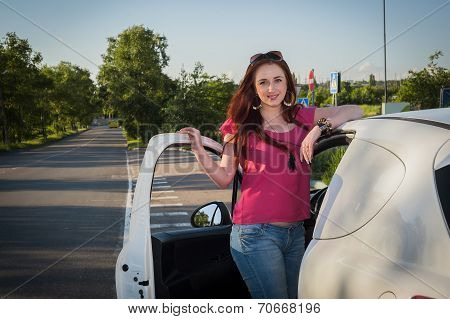 Beautiful smiling redhead woman traveling by car