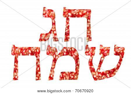 Chag Sameach (Happy holiday) written in hebrew with Pomegranate seeds