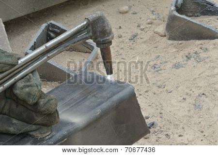Workers at construction site cutting metal using blowtorch