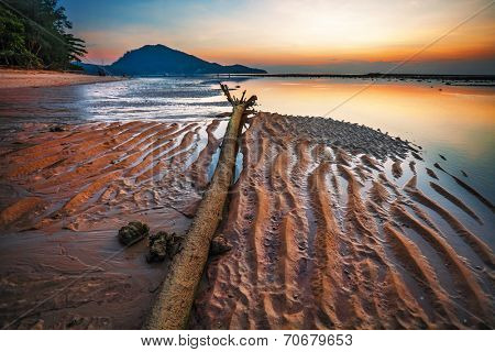 Tropical beach in ebb time on sunset background
