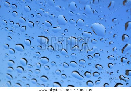 Blue rain drops on glass