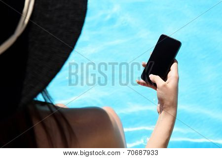 Closeup image of female hand using smartphone