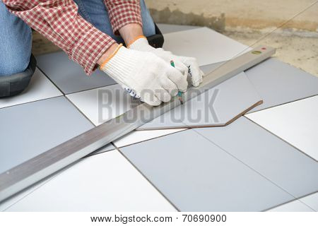 Tiler marks the tile during the floor installation