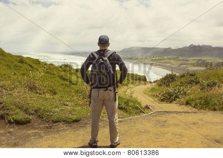 Male hiker looking at a beautiful ocean view in New Zealand