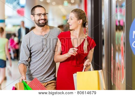 Couple at shop window in mall shopping