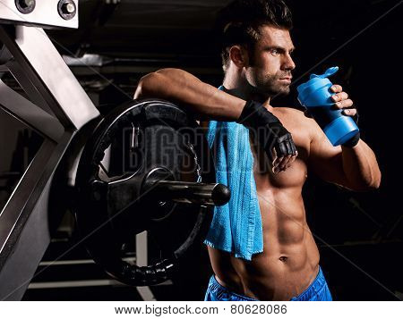 the man in the gym drinking from the shaker