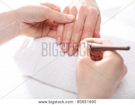 Manicure cutting skins woman to a beautician
