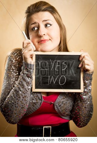Thoughtful Woman Holding Blackboard With Yes And No Options