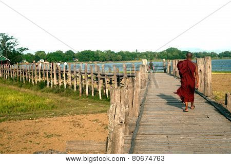 Monks  And Visitors Walking On The U-Bein Bridge.