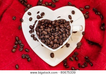Heart Shaped Cup With Coffee Beans On Red
