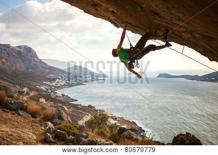 Male climber climbing overhanging rock