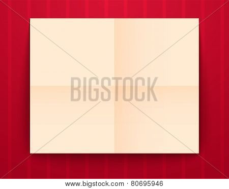 Empty old sheet of paper folded in fourfold on red background