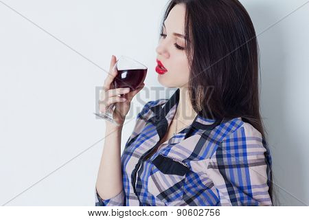 Girl languidly looks at glass of red wine
