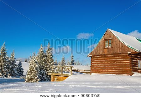 Wooden house in winter landscape, sunny day
