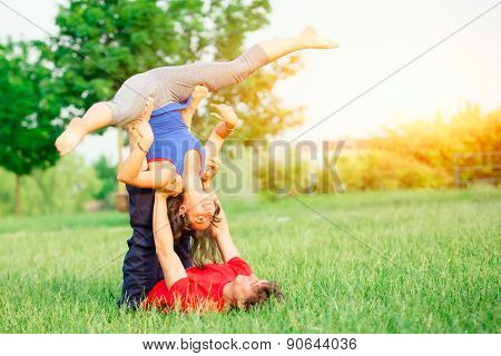 Couple Practicing Acroyoga In The Park