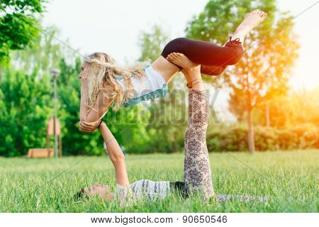 Couple Practicing Acroyoga In The Park